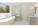 Bright bathroom with marble floors, soaking tub, glass shower, and natural light at 312 Meadow Dr, Alpharetta, GA 30009