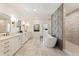 Bright bathroom featuring a soaking tub, double vanity, stone floors, and a walk-in shower at 312 Meadow Dr, Alpharetta, GA 30009
