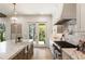 Bright kitchen features a marble countertop island, white cabinets, and stainless steel stove at 312 Meadow Dr, Alpharetta, GA 30009