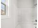 Close up of a bright white shower and tub with shelving and chrome fixtures at 3866 Kastler Dr, South Fulton, GA 30349