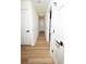 Hallway with wood grain flooring, white walls and trim, and dark hardware on the doors at 4336 Parkview Dr, Lithia Springs, GA 30122
