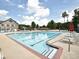 Large community pool with lane markers, plenty of pool chairs and umbrellas, and a view of the clubhouse at 6015 Crestwick Way, Cumming, GA 30040