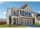 Beautiful two-story home with gray siding, brick accents, and a well-maintained front lawn on a sunny day at 6015 Crestwick Way, Cumming, GA 30040