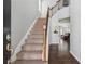 Inviting home foyer with carpeted stairs, hardwood floors, and view into an open living space at 6015 Crestwick Way, Cumming, GA 30040