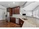 Modern kitchen featuring granite countertops, stainless steel appliances and dark wood cabinets at 6015 Crestwick Way, Cumming, GA 30040