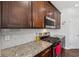 Well-lit kitchen with granite countertops, dark wood cabinets, and stainless steel gas range at 6015 Crestwick Way, Cumming, GA 30040
