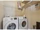 Functional laundry room includes modern washer and dryer set with shelving for storage of supplies at 6015 Crestwick Way, Cumming, GA 30040