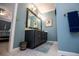 Stylish bathroom featuring a dark vanity with a large mirror, complemented by blue walls and gray tile flooring at 1187 Plantation Dr, Villa Rica, GA 30180