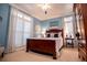 Comfortable bedroom featuring hardwood furniture, white shutters on large windows, and light blue walls at 1187 Plantation Dr, Villa Rica, GA 30180