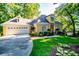 Charming yellow home featuring a well-manicured lawn, attached garage, and beautiful landscaping at 1187 Plantation Dr, Villa Rica, GA 30180