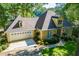 Charming home featuring a two-car garage, manicured landscaping, and a unique turret-style architectural detail at 1187 Plantation Dr, Villa Rica, GA 30180