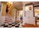 Welcoming foyer with black and white tile flooring, a staircase, and built-in cabinets, creating a grand entrance at 1187 Plantation Dr, Villa Rica, GA 30180