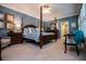 Main bedroom with a four-poster bed, blue walls, plantation shutters, and serene decor at 1187 Plantation Dr, Villa Rica, GA 30180