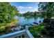 Waterfront home with multiple docks, boats, lush landscaping, and a serene lake view under a blue sky at 1187 Plantation Dr, Villa Rica, GA 30180
