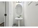 Stylish powder room boasts a pedestal sink, oval mirror, and modern fixtures with neutral wall color at 1901 Creel Ln, Atlanta, GA 30349