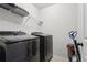 Modern laundry room with front loading washer, dryer, wire shelving and cleaning supplies at 1901 Creel Ln, Atlanta, GA 30349