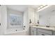 Bright main bathroom featuring double sinks, granite countertops, a tub, and a large window at 1901 Creel Ln, Atlanta, GA 30349