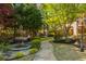 Serene backyard garden featuring a stone fountain, stone pathway, and lush plantings with decorative lighting at 2461 Oak Grove Ne Ests, Atlanta, GA 30345