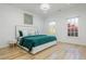 Serene bedroom with a stylish bed dressed in a teal quilt, complemented by white walls and natural light from windows at 2461 Oak Grove Ne Ests, Atlanta, GA 30345