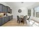 Bright dining area with modern light fixture, windows, custom gray cabinets, and hardwood floors at 2461 Oak Grove Ne Ests, Atlanta, GA 30345