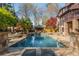 Large pool and stone patio surrounded by a green lawn and mature trees at 2461 Oak Grove Ne Ests, Atlanta, GA 30345