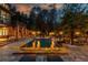 Backyard pool with a fire feature, stone surround, and ambient lighting, ideal for evening entertainment at 2461 Oak Grove Ne Ests, Atlanta, GA 30345