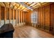 An unfinished room in the basement with wood flooring, visible framing, utilities, and a window for natural light at 57 Sorghum Ct, Dallas, GA 30157