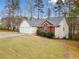 Exterior elevation of a home with brick and vinyl siding, a two-car garage, and a well-manicured lawn at 57 Sorghum Ct, Dallas, GA 30157