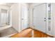 Bright foyer features gleaming hardwood floors, a stylish white door, and a glimpse of the bathroom at 57 Sorghum Ct, Dallas, GA 30157