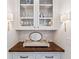 Butler's pantry with upper display cabinets, wood countertop and sconces at 891 Glenbrook Nw Dr, Atlanta, GA 30318