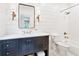 Well-lit bathroom with a dark vanity, tub, and shiplap accent wall at 891 Glenbrook Nw Dr, Atlanta, GA 30318