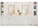 Bright bathroom featuring a double vanity with white cabinets, marble countertops, and gold framed mirrors at 891 Glenbrook Nw Dr, Atlanta, GA 30318
