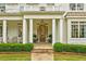 Close-up of the home's entrance featuring a covered porch, stone pathway, and manicured landscaping at 891 Glenbrook Nw Dr, Atlanta, GA 30318