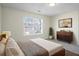 Bedroom with view of exterior, bed, and neutral colored walls at 11352 Michelle Way, Hampton, GA 30228
