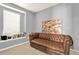 Cozy seating area features tufted leather sofa, with natural light from the large window, and an abstract art piece at 411 Sureyya Dr, Canton, GA 30114
