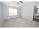 This is a bedroom with a window, light carpet, and an ensuite bathroom at 1851 Devon Dr, Atlanta, GA 30311