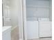 A laundry room features a washing machine and dryer, next to an open door at 1851 Devon Dr, Atlanta, GA 30311