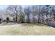 A large, flat, grassy backyard is partially shaded by mature trees and is fenced in at 40 Kingfisher Walk, Covington, GA 30014