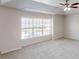 Bright bedroom with a ceiling fan and large windows overlooking a yard at 40 Kingfisher Walk, Covington, GA 30014