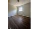 A well-lit bedroom featuring wood-look flooring, neutral walls, and a large window at 4701 Flat Shoals Rd, Union City, GA 30291