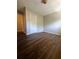 A bright bedroom featuring wood-look flooring, neutral walls, and a closet with white doors at 4701 Flat Shoals Rd, Union City, GA 30291