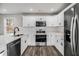 Bright kitchen with stainless steel appliances, white cabinets, and subway tile backsplash with hardwood floors at 6355 Akins Way, Cumming, GA 30041