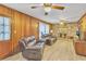 Spacious living room featuring wood-paneled walls, ceiling fans, and a brick fireplace at 3347 Stonecrest Ct, Atlanta, GA 30341