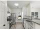 Well-lit kitchen featuring stainless steel appliances, granite countertops, white cabinetry, and a window at 4917 Walden Lake Sq, Decatur, GA 30035