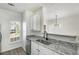 Modern kitchen featuring stainless steel dishwasher, granite countertops, updated faucet, and white cabinetry at 4917 Walden Lake Sq, Decatur, GA 30035