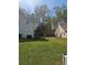 Large backyard with green grass, trees, and a fire pit creating an inviting outdoor space at 68 Georgias Ln, Dallas, GA 30157