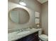 Stylish bathroom with granite countertop, round mirror, and modern fixtures at 1788 Hanover West Ct, Lawrenceville, GA 30043
