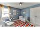 Blue Bedroom featuring an accent rug, large windows, and a comfortable chair and ottoman at 1788 Hanover West Ct, Lawrenceville, GA 30043