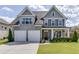 Charming two-story home featuring a two-car garage, manicured lawn, and covered front porch at 1788 Hanover West Ct, Lawrenceville, GA 30043