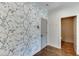 Hallway with decorative wallpaper, hardwood floors, and access to a powder room at 1788 Hanover West Ct, Lawrenceville, GA 30043